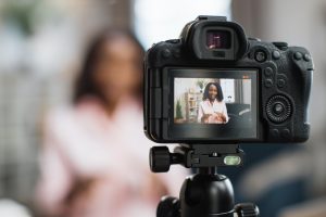 Female influencer filming video while sitting at home