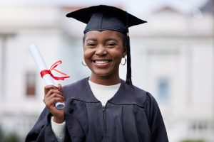 Portrait of a young woman holding her diploma on graduation day