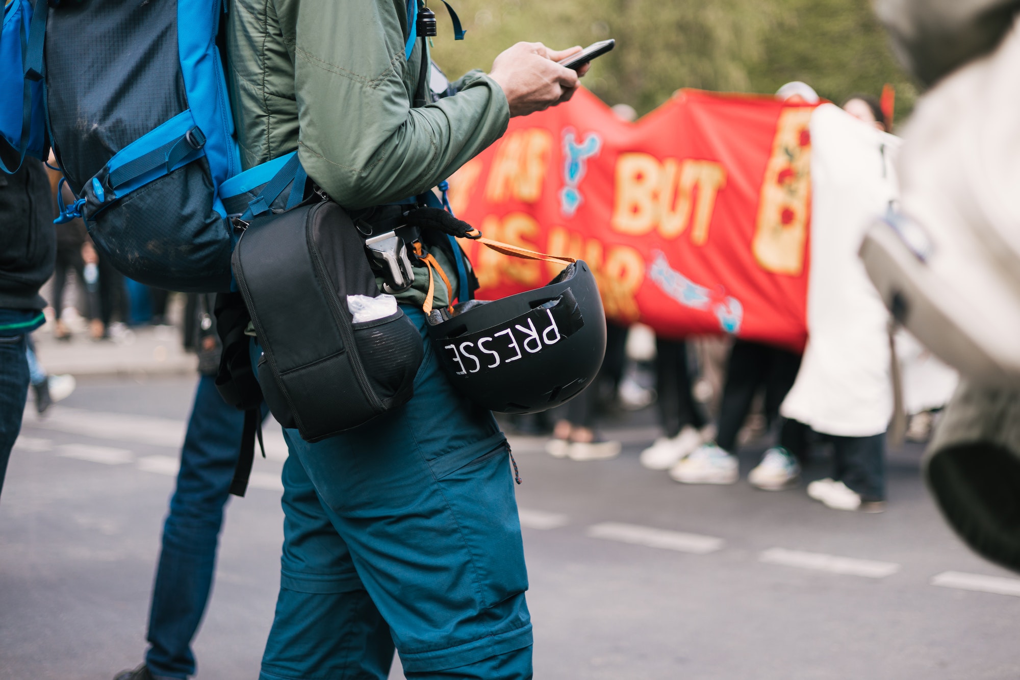 Journalist at a demonstration with mobile phone in hand